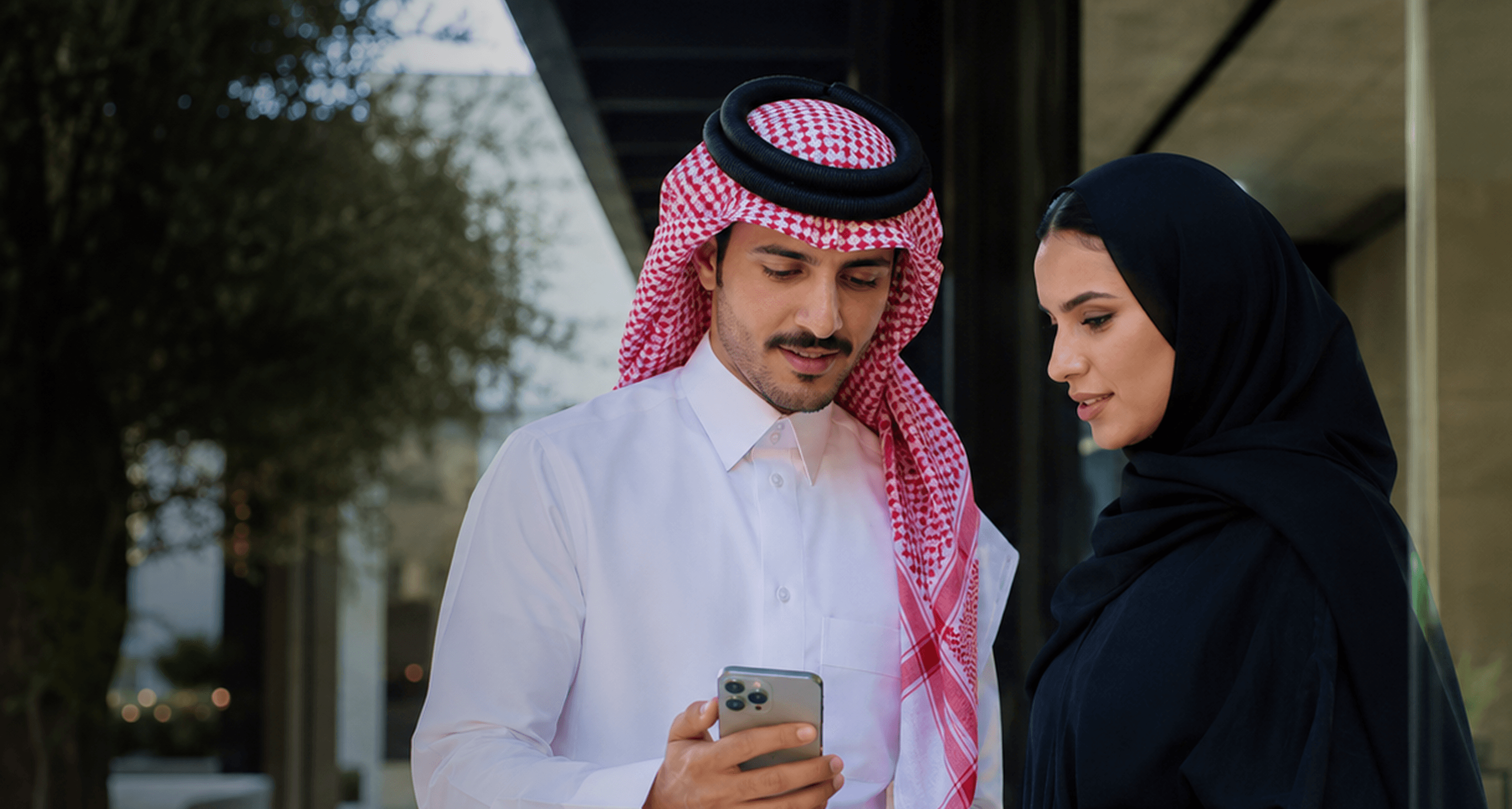 A couple looking at a phone together outdoors